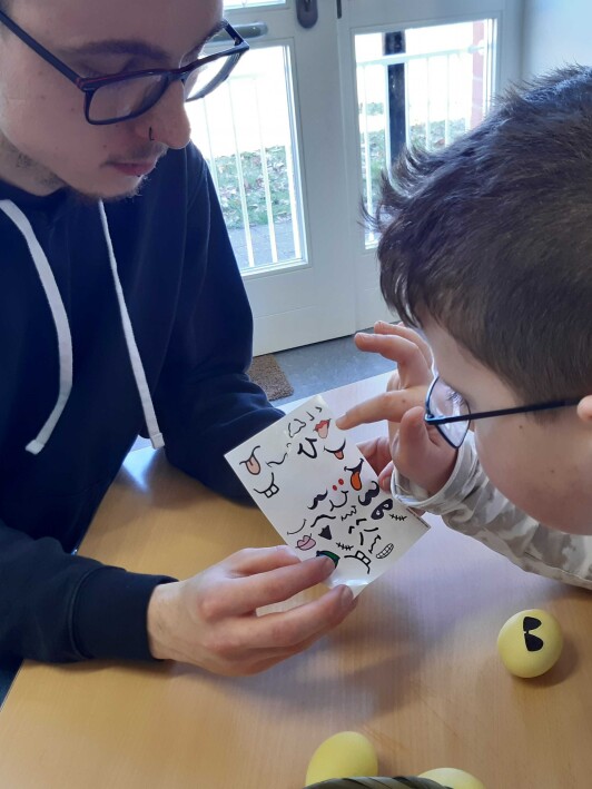 BFDler untzerstützt Schüler bei der Auswahl eines Gefühleaufklebers