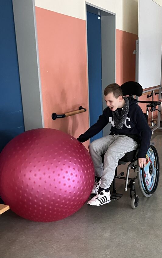 Schüler im Rollstuhl mit Gymnastikball