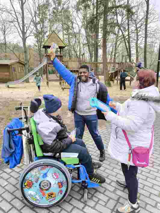 Zwei Schüler mit Ostergeschenken und eine Betreuerin mit Talker in der Hand