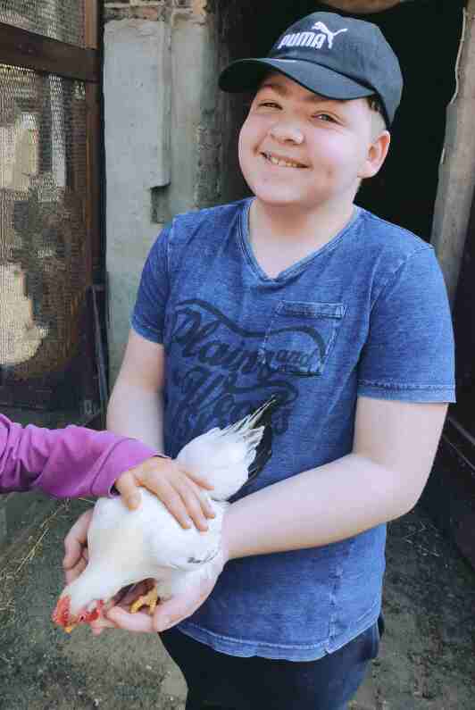 Schüler hält ein Huhn in der Hand